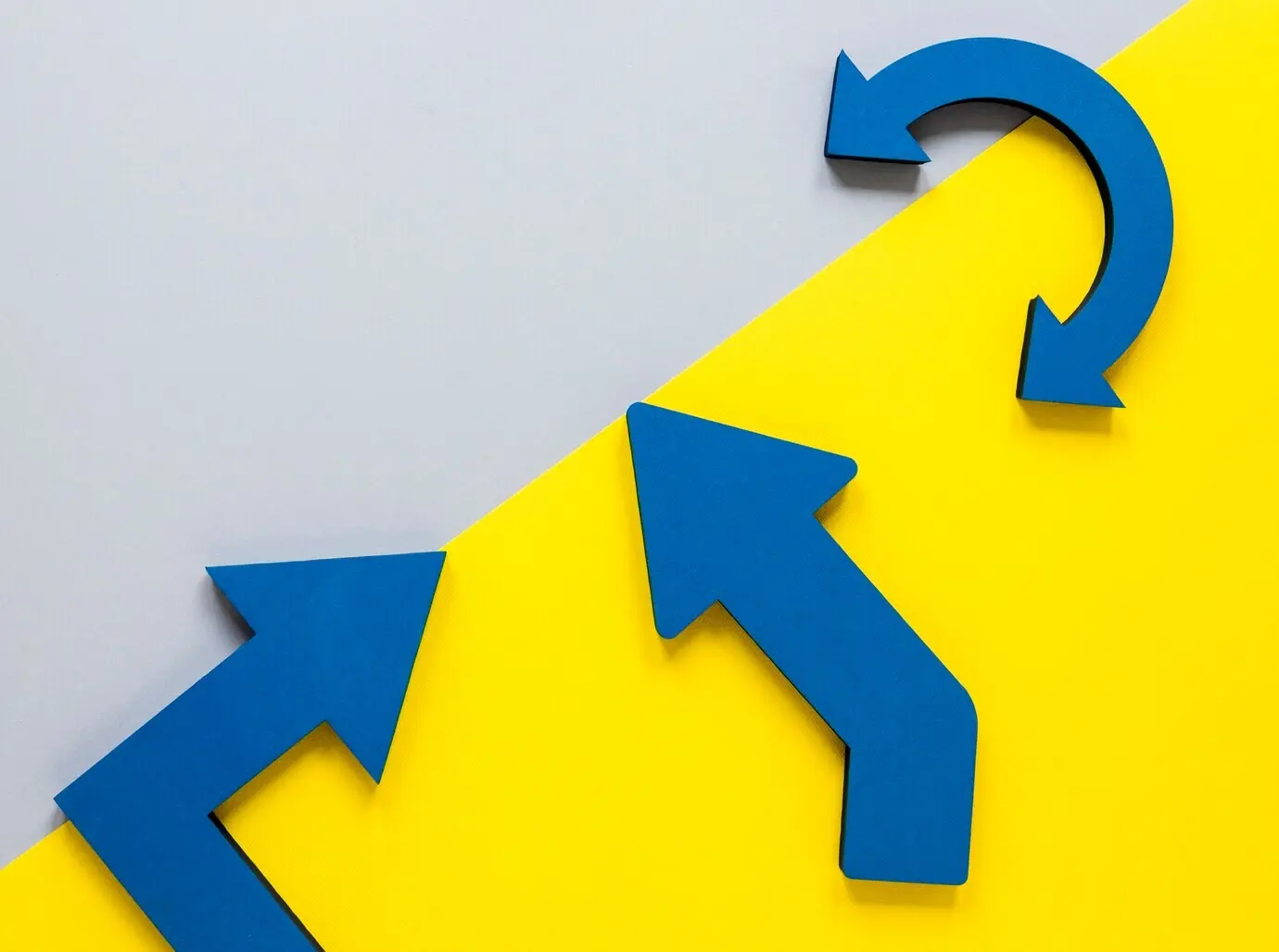 Draufsicht mit blauen Pfeilen und gelbem Karton auf weißem Hintergrund