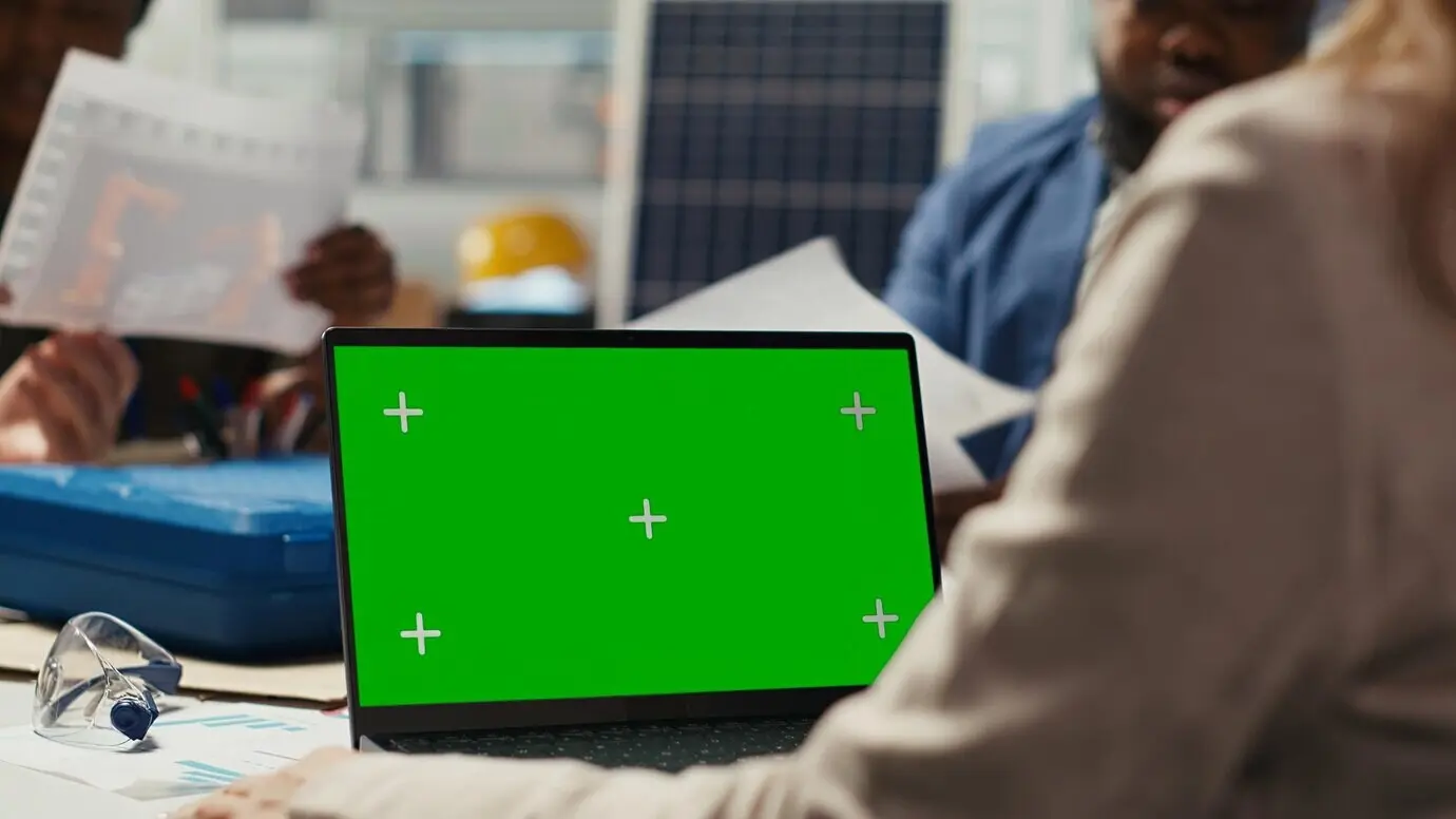 Forschende in einer Industrieanlage arbeiten mithilfe eines Mock-up-Laptops an Durchbrüchen.